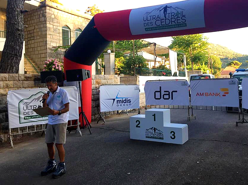Maxime Chaya waits at the finishing line with the Midis Group logo in the background