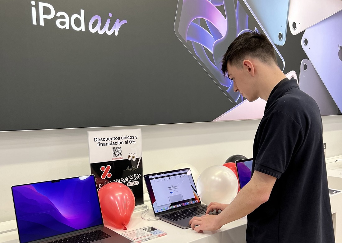 a young man is seen looking at an iPad in a retail site