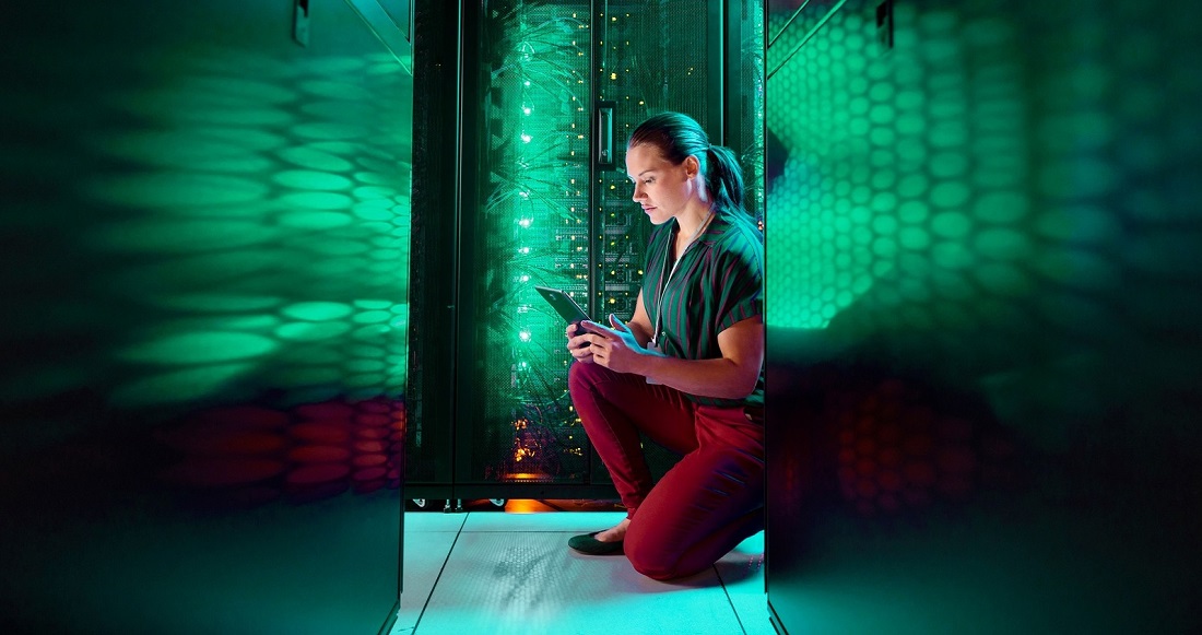 a woman is seen in a server center with green light reflections all around