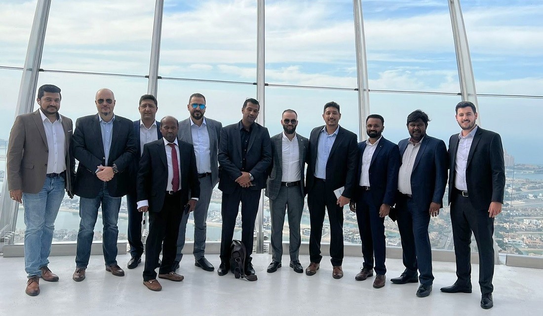 Eleven men seen in a group photo outdoors in a skyscraper observation deck