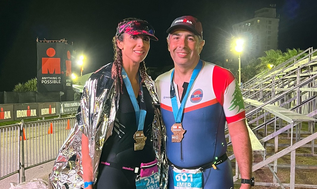 two people in running gear wearing medals after completing a race
