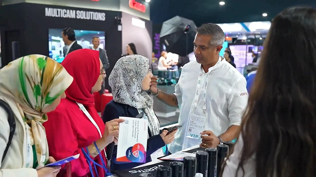 a man speaking to three women at a tech event