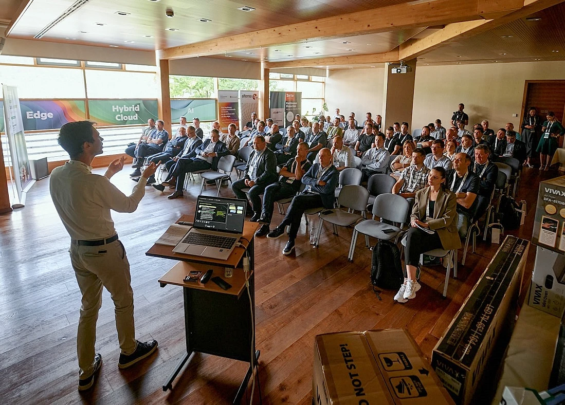 un homme est vu de dos alors qu'il se présente devant une salle pleine de monde