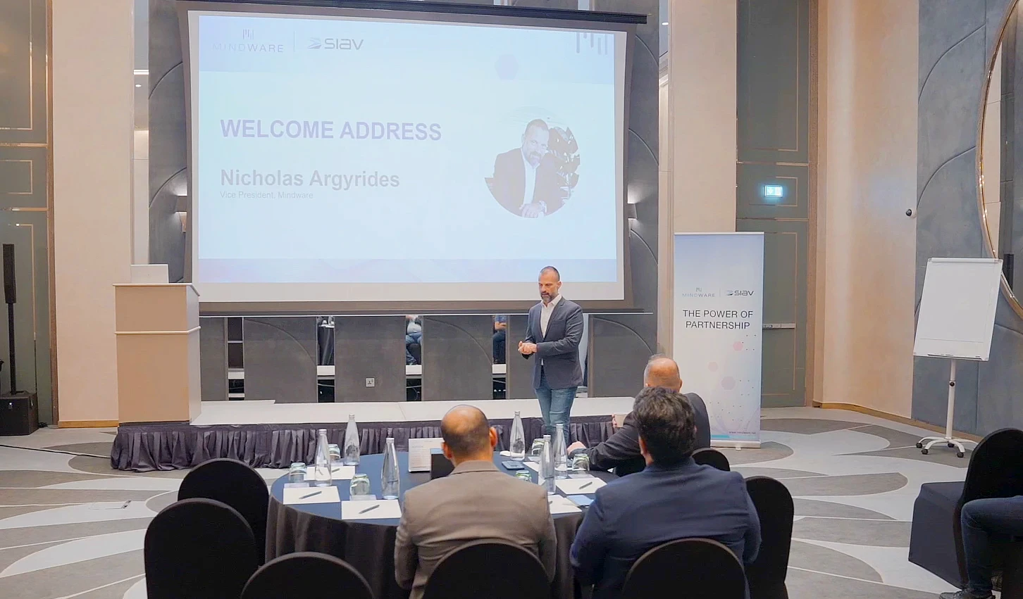 a man presents to an audience in front of a presentation screen