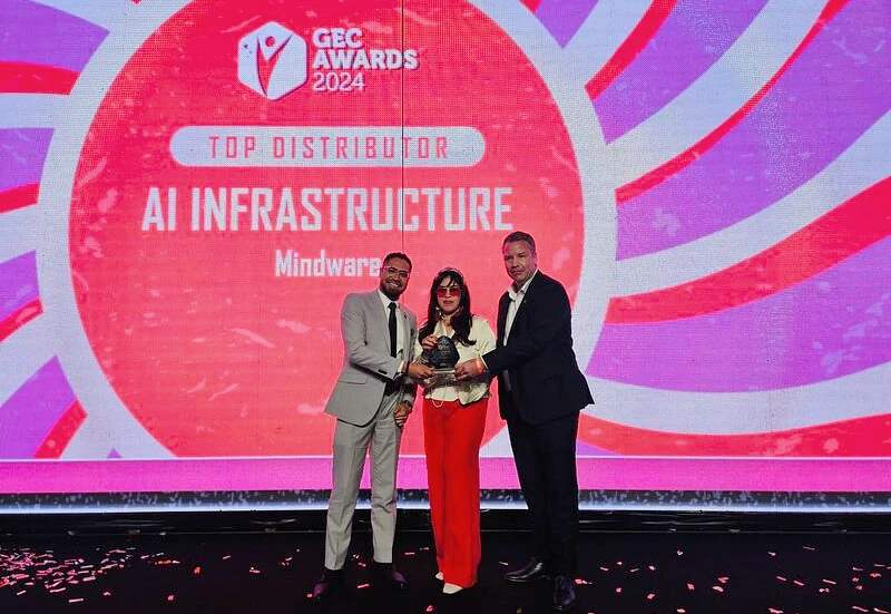 three people are seen on a presentation stage accepting an award