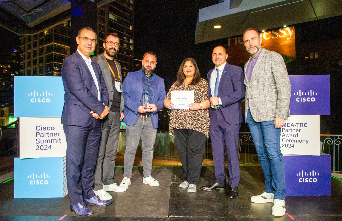 six people on a presentation stage with a trophy being handed over