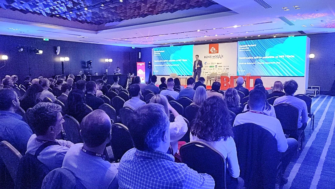 a large audience watches a speaker at a hi-tech conference