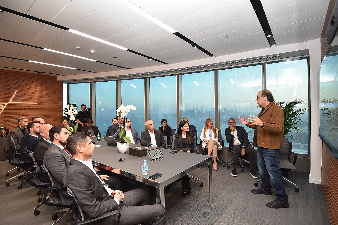 a man is seen presenting to a group of people in a boardroom setting