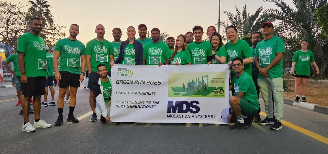 people in green t-shirts are gathered at the start of a fun run