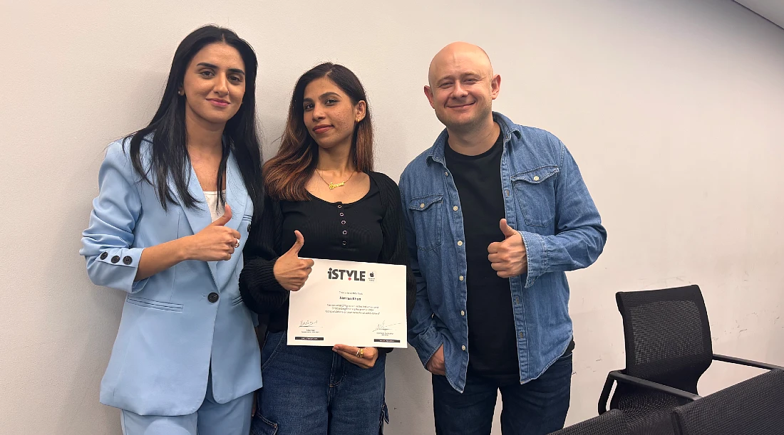 three people in a group photo with the central person holding a certificate