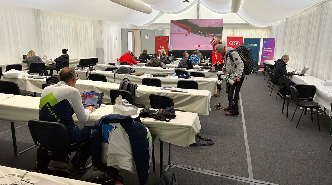 interior of a media centre with rows of tables and chairs and a large screen at the end of the room